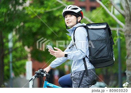 都会で自転車に乗りデリバリーをする男性 都会で自転車に乗りデリバリーをする男性 80903020