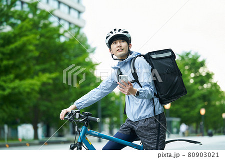 都会で自転車に乗りデリバリーをする男性 80903021