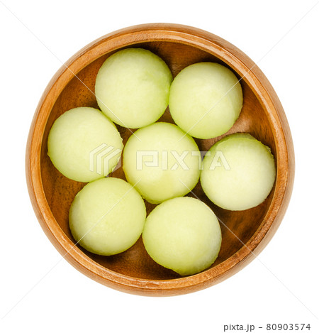 Galia melon balls, in a wooden bowl. Freshly cut out with a melon baller, ready-to-eat pieces of a ripe fruit of Cucumis melo var. reticulatus, a sweet and aromatic melon, also known as sarda. Photo. Galia melon balls, in a wooden bowl. Freshly cut out with a melon baller, ready-to-eat pieces of a ripe fruit of Cucumis melo var. reticulatus, a sweet and aromatic melon, also known as sarda. Photo. 80903574
