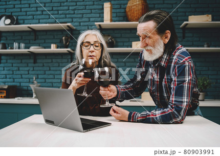 Happy senior couple using laptop at the kitchen 80903991
