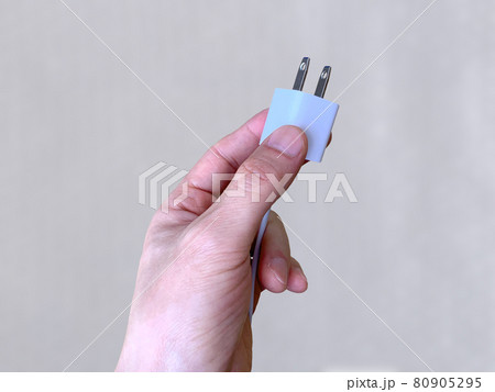 手に持った充電コード 80905295