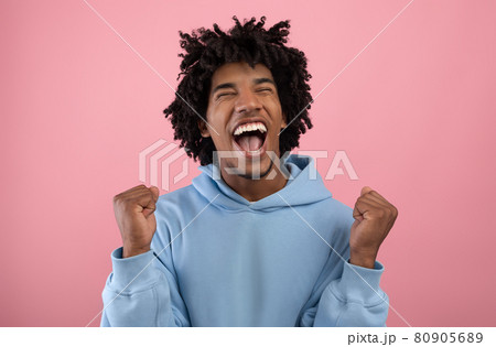 Huge win, great luck. Handsome African American teenager making YES gesture, shouting OMG on pink studio background Huge win, great luck. Handsome African American teenager making YES gesture, shouting OMG on pink studio background 80905689