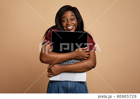 Delighted young black woman enjoying her new modern laptop Delighted young black woman enjoying her new modern laptop 80905729