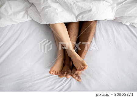 Top view of young multiracial couple lying in bed after lovemaking. Erotic games, sexual foreplay, intimate relationship 80905871