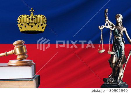 Law and justice in Liechtenstein. Statue of themis and the gavel of the judge against the background of the flag of Liechtenstein. Law and justice concept 80905940