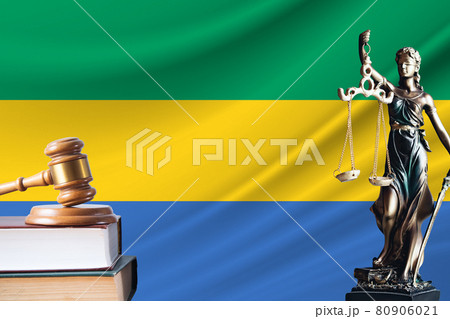 Law and justice in Gabon. Statue of themis and the gavel of the judge against the background of the flag of Gabon. Law and justice concept Law and justice in Gabon. Statue of themis and the gavel of the judge against the background of the flag of Gabon. Law and justice concept 80906021