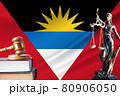 Law and justice in Antigua and Barbuda. Statue of themis and the gavel of the judge against the background of the flag of Antigua and Barbuda. Law and justice concept 80906050