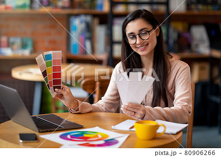 Creative latin woman web-designer working with color palette while sitting at cafe with laptop, free space Creative latin woman web-designer working with color palette while sitting at cafe with laptop, free space 80906266
