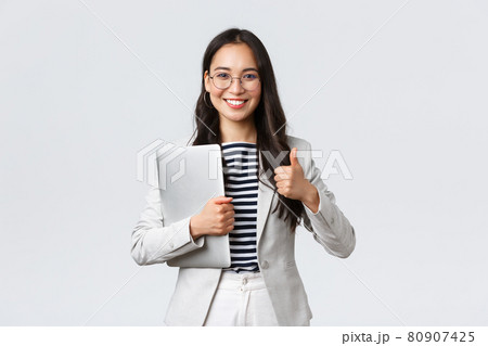Business, finance and employment, female successful entrepreneurs concept. Confident good-looking therapist or businesswoman in white suit, holding laptop and showing thumbs-up Business, finance and employment, female successful entrepreneurs concept. Confident good-looking therapist or businesswoman in white suit, holding laptop and showing thumbs-up 80907425
