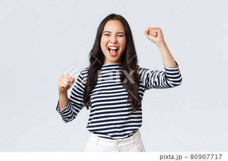Lifestyle, people emotions and casual concept. Excited happy asian woman attend sport competition, rooting and chanting for team, raising hands up and shout yes supportive Lifestyle, people emotions and casual concept. Excited happy asian woman attend sport competition, rooting and chanting for team, raising hands up and shout yes supportive 80907717