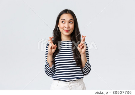 Lifestyle, people emotions and casual concept. Hopeful cute wishful asian girl cross fingers good luck, looking up at lottery and making wish, dreaming of something, white background 80907736