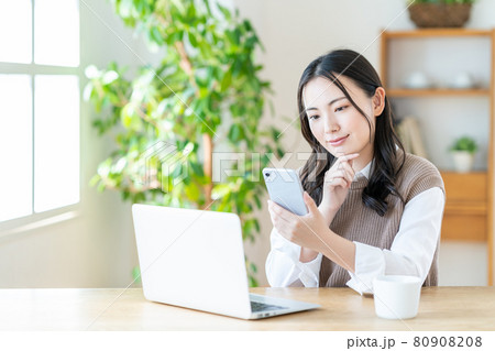 リビングでテレワークをする若い女性。 リビングでテレワークをする若い女性。 80908208