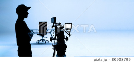 Video production behind the scenes. Making of TV commercial movie that film crew team lightman and cameraman working together with film director in studio. film production concept. Silhouette style. 80908799