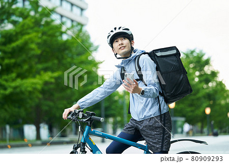 都会で自転車に乗りデリバリーをする男性 80909293