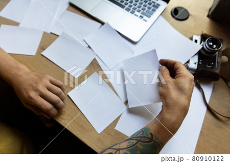 One young Caucasian man, photographer, cameraman with professional camera, equipment during working at office, indoors. Concept of occupation, job, education 80910122