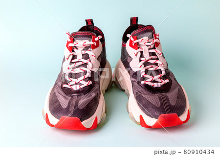 Women's, fashionable, sports sneakers, black with red accents on a blue background. Women's, fashionable, sports sneakers, black with red accents on a blue background. 80910434