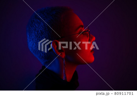Portrait of beautiful young woman with short hair wearing glasses in neon light Portrait of beautiful young woman with short hair wearing glasses in neon light 80911701