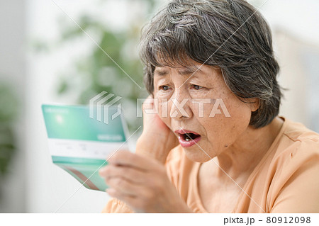 シニア女性　通帳　悩む 80912098