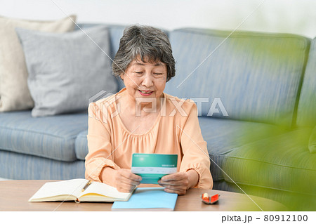 シニア女性　通帳　悩む 80912100