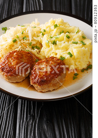 Hot Norwegian pork patties Medisterkaker served with mashed potatoes and sauerkraut close-up in a plate. vertical Hot Norwegian pork patties Medisterkaker served with mashed potatoes and sauerkraut close-up in a plate. vertical 80912363