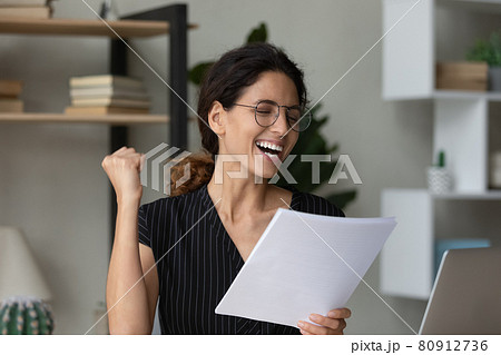 Close up overjoyed businesswoman in glasses celebrating achievement, reading letter 80912736