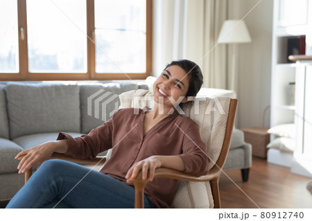 Portrait of happy Indian woman relax in cozy armchair Portrait of happy Indian woman relax in cozy armchair 80912740