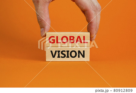 Global vision symbol. Wooden blocks with words 'Global vision' on beautiful orange background. Businessman hand. Business and global vision concept. Copy space. Global vision symbol. Wooden blocks with words 'Global vision' on beautiful orange background. Businessman hand. Business and global vision concept. Copy space. 80912809
