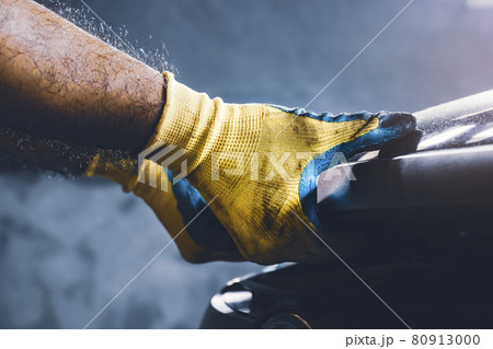 Technician hand pulling up car hood for maintenance in the repair garage Technician hand pulling up car hood for maintenance in the repair garage 80913000