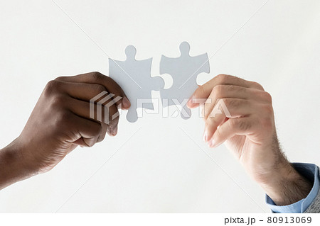 Close up of diverse employees connect jigsaw pieces 80913069