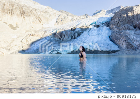 Adventurous White Caucasian Adult Woman Swimming in Ice Cold Glacier Lake 80913175
