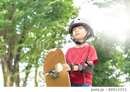 スケートボードを持って立つ幼い男の子 80913351