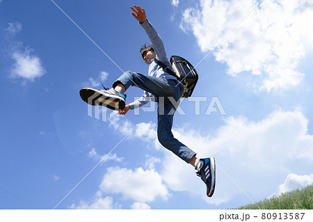 青空のもとでジャンプする男の子 80913587