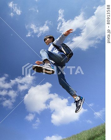 青空のもとでジャンプする男の子 80913588