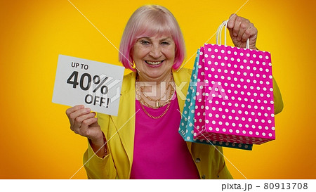 Elderly granny woman showing shopping bags and Up To 40 Percent Off inscriptions text, Black Friday 80913708
