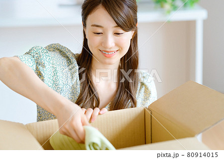 リビングで服を段ボールに詰める若い主婦 リビングで服を段ボールに詰める若い主婦 80914015