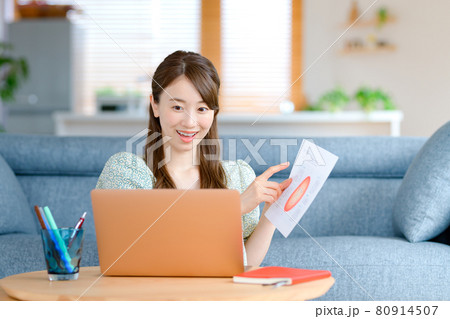 自宅のリビングでテレワークする若いビジネスウーマン 自宅のリビングでテレワークする若いビジネスウーマン 80914507