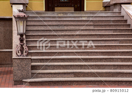 marble staircase with stone steps and iron forged lantern in a retro style, close-up of the architecture of the house with street lighting, nobody. 80915012