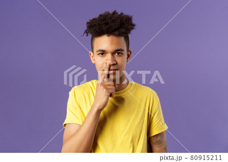 Close-up portrait of funny and unappropriate young hispanic teenage guy picking nose with finger, smiling and looking at camera, standing purple background, have bad habit Close-up portrait of funny and unappropriate young hispanic teenage guy picking nose with finger, smiling and looking at camera, standing purple background, have bad habit 80915211