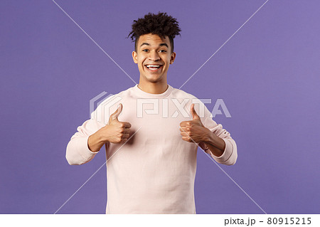 Portrait of upbeat, happy smiling man left pleased after using company service, studying at online language school, show thumbs-up and look camera, recommending, stand purple background 80915215