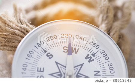 Close-up of compass with sun glare and rope 80915245