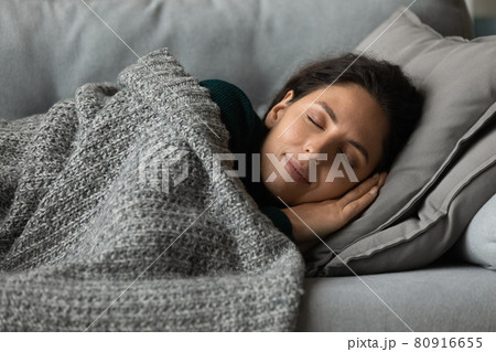 Close up peaceful woman with closed eyes resting on couch 80916655