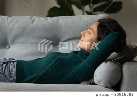 Close up profile peaceful young woman sleeping on cozy sofa 80916683