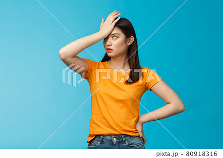 Annoyed arrogant asian girl punch forehead make facepalm sign, roll eyelids irritated pissed, cannot stand lame talks look disappointed ingorant, unwilling to listen, stand blue background 80918316