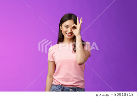 friendly cheerful young asian lady enjoy perfect summer day, show okay ok sign on eye, look through finger-circle, stand purple background joyful, recommend good place, feel excellent 80918318