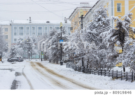 View of an empty snow-covered city street during a snowfall 80919846