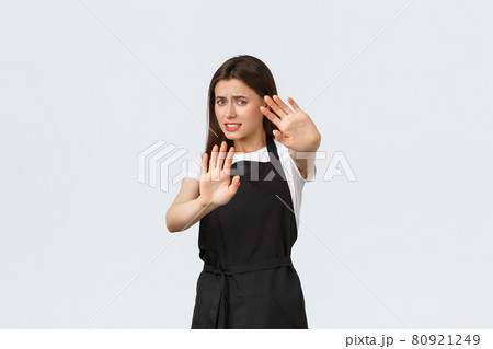 Grocery store employees, small business and coffee shops concept. Displeased young female cafe worker protect herself from flashlight or cameras of strange visitor, white background Grocery store employees, small business and coffee shops concept. Displeased young female cafe worker protect herself from flashlight or cameras of strange visitor, white background 80921249