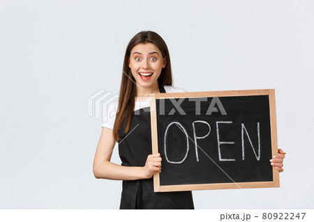 Grocery store employees, small business and coffee shops concept. Excited and cheerful cute female barista invite guests come enjoy drinks, showing we are open sign, stand white background Grocery store employees, small business and coffee shops concept. Excited and cheerful cute female barista invite guests come enjoy drinks, showing we are open sign, stand white background 80922247