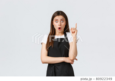 Small business, employees and coffee shop concept. Excited barista raising index finger as saying suggestion out loud. Creative saleswoman have plan. Waiter thinking-up solution Small business, employees and coffee shop concept. Excited barista raising index finger as saying suggestion out loud. Creative saleswoman have plan. Waiter thinking-up solution 80922349