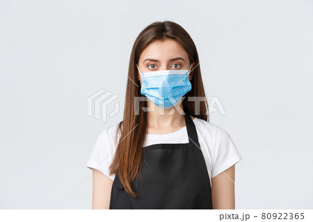 Covid-19 social distancing, cafe employees, coffee shops and coronavirus concept. Close-up of female barista in medical mask, follow all preventing virus measures, serving food to customers Covid-19 social distancing, cafe employees, coffee shops and coronavirus concept. Close-up of female barista in medical mask, follow all preventing virus measures, serving food to customers 80922365