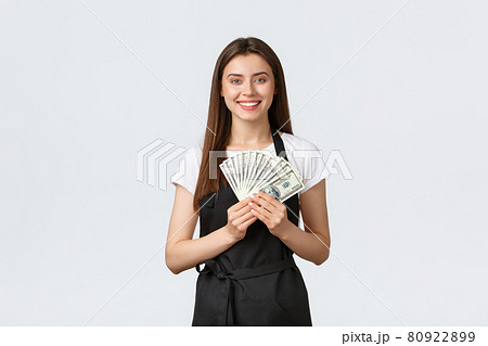 Grocery store employees, small business and coffee shops concept. Excited cheerful young female barista earn lots tips, have money to travel summer vacation, smiling happy, stand white background Grocery store employees, small business and coffee shops concept. Excited cheerful young female barista earn lots tips, have money to travel summer vacation, smiling happy, stand white background 80922899